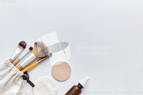 Image of make up brushes, cosmetics and cotton swabs