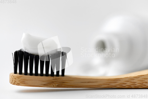 Image of natural wooden toothbrush with toothpaste on it