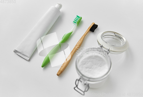 Image of toothbrushes, toothpaste and soda in jar