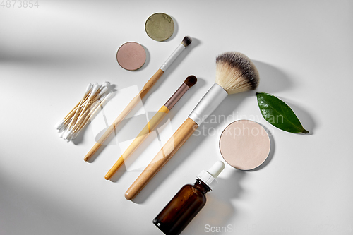 Image of make up brushes, cosmetics and cotton swabs