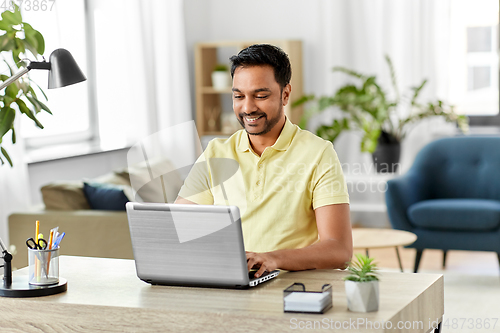 Image of indian man with laptop working at home office