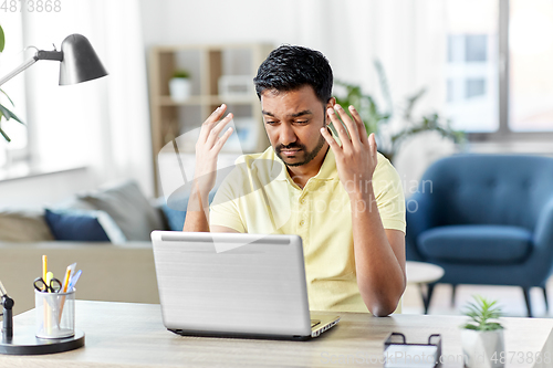 Image of indian man with laptop working at home office