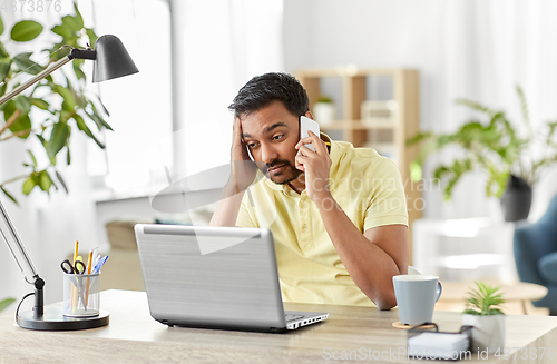 Image of man calling on smartphone at home office