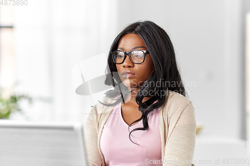 Image of african woman with laptop working at home office