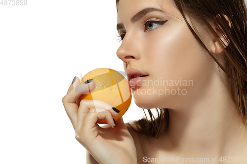 Image of Close up of beautiful young woman with juicy orange over white background. Cosmetics and makeup, natural and eco treatment, skin care.