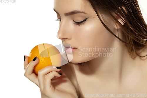 Image of Close up of beautiful young woman with juicy orange over white background. Cosmetics and makeup, natural and eco treatment, skin care.