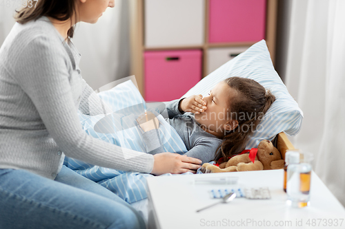 Image of mother and sick little daughter in bed at home