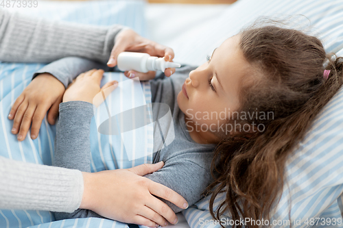 Image of mother with nasal spray treats sick daughter