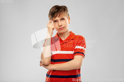 Image of portrait of thinking boy in red polo t-shirt