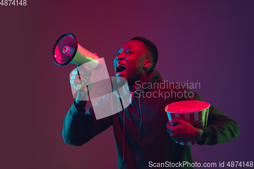Image of African-american man\'s portrait isolated on gradient studio background in neon light