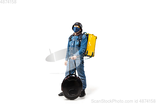 Image of Too much orders. Contacless delivery service during quarantine. Man delivers food and shopping bags during isolation, wearing gloves and face mask.