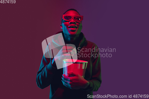 Image of African-american man\'s portrait isolated on gradient studio background in neon light