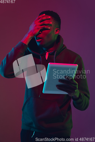 Image of African-american man\'s portrait isolated on gradient studio background in neon light