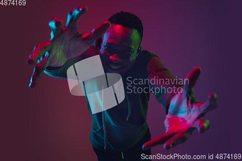 Image of African-american man\'s portrait isolated on gradient studio background in neon light