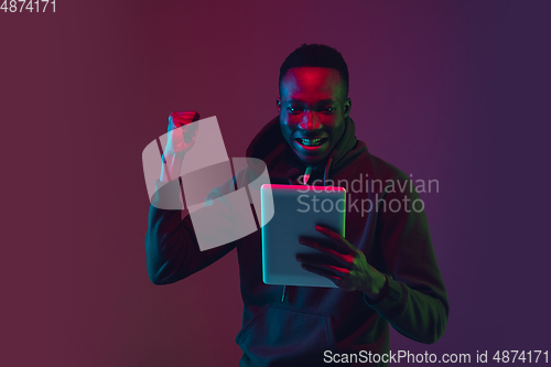 Image of African-american man\'s portrait isolated on gradient studio background in neon light