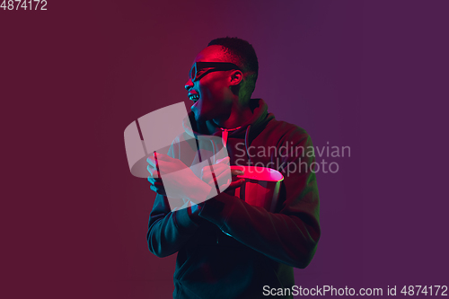 Image of African-american man\'s portrait isolated on gradient studio background in neon light