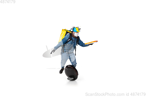 Image of Too much orders. Contacless delivery service during quarantine. Man delivers food and shopping bags during isolation, wearing gloves and face mask.