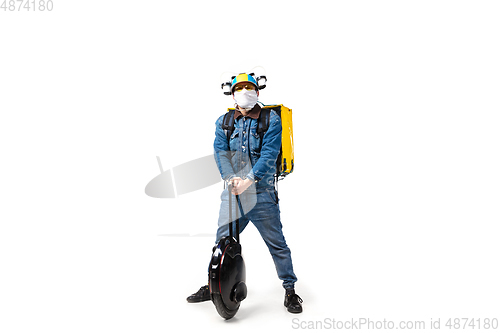 Image of Too much orders. Contacless delivery service during quarantine. Man delivers food and shopping bags during isolation, wearing gloves and face mask.