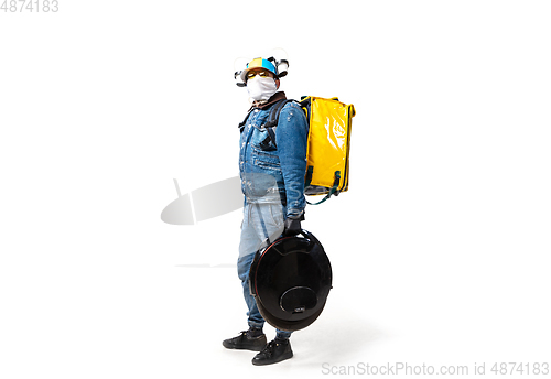 Image of Too much orders. Contacless delivery service during quarantine. Man delivers food and shopping bags during isolation, wearing gloves and face mask.