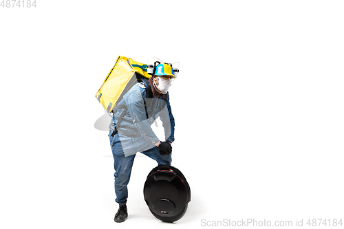 Image of Too much orders. Contacless delivery service during quarantine. Man delivers food and shopping bags during isolation, wearing gloves and face mask.