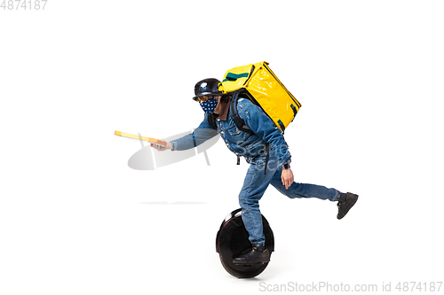 Image of Too much orders. Contacless delivery service during quarantine. Man delivers food and shopping bags during isolation, wearing gloves and face mask.