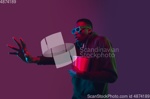 Image of African-american man\'s portrait isolated on gradient studio background in neon light