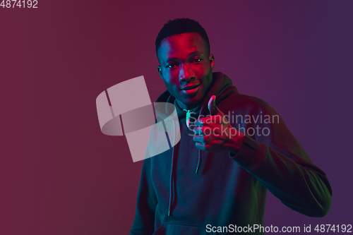 Image of African-american man\'s portrait isolated on gradient studio background in neon light
