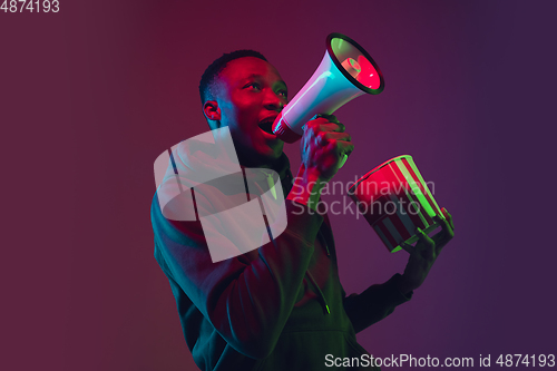 Image of African-american man\'s portrait isolated on gradient studio background in neon light