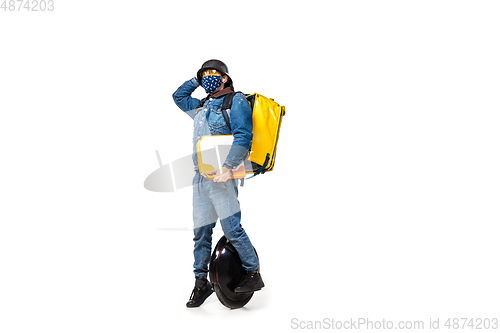 Image of Too much orders. Contacless delivery service during quarantine. Man delivers food and shopping bags during isolation, wearing gloves and face mask.