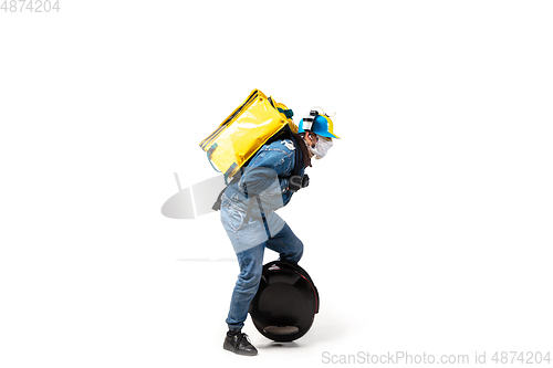 Image of Too much orders. Contacless delivery service during quarantine. Man delivers food and shopping bags during isolation, wearing gloves and face mask.