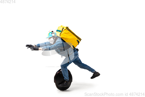 Image of Too much orders. Contacless delivery service during quarantine. Man delivers food and shopping bags during isolation, wearing gloves and face mask.