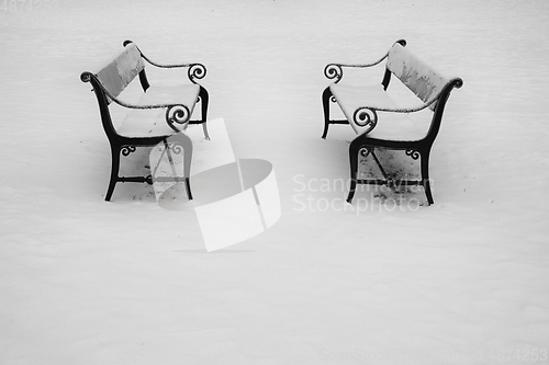 Image of Two benches in the snow.