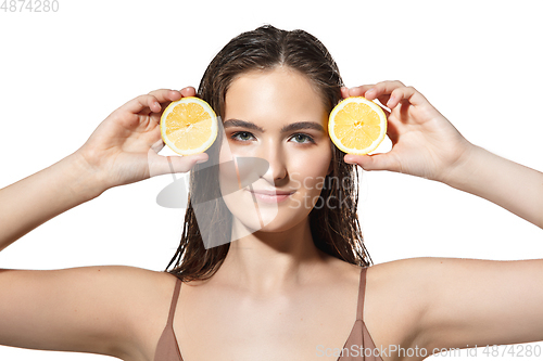 Image of Citrus. Close up of beautiful female face with lemon slices over white background. Cosmetics and makeup, natural and eco treatment, skin care.