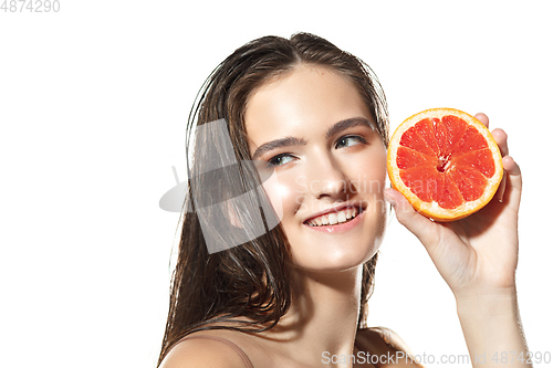 Image of Close up of beautiful female face with grapefruit slices over white background. Cosmetics and makeup, natural and eco treatment, skin care.