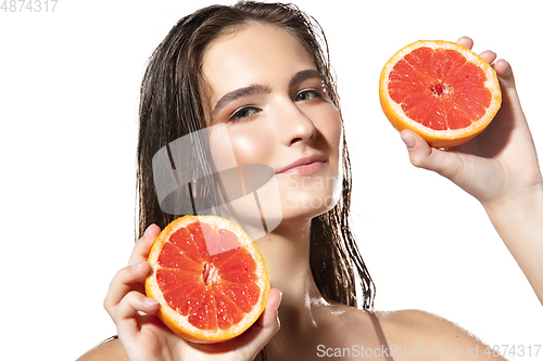 Image of Close up of beautiful female face with grapefruit slices over white background. Cosmetics and makeup, natural and eco treatment, skin care.