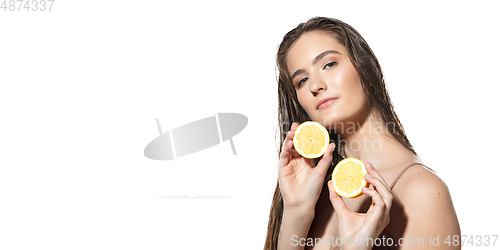 Image of Citrus. Close up of beautiful female face with lemon slices over white background. Cosmetics and makeup, natural and eco treatment, skin care.