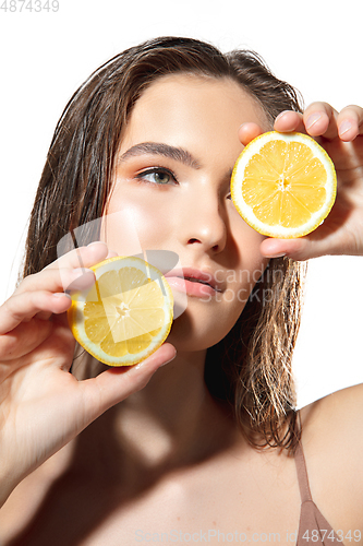 Image of Citrus. Close up of beautiful female face with lemon slices over white background. Cosmetics and makeup, natural and eco treatment, skin care.