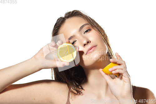 Image of Citrus. Close up of beautiful female face with lemon slices over white background. Cosmetics and makeup, natural and eco treatment, skin care.