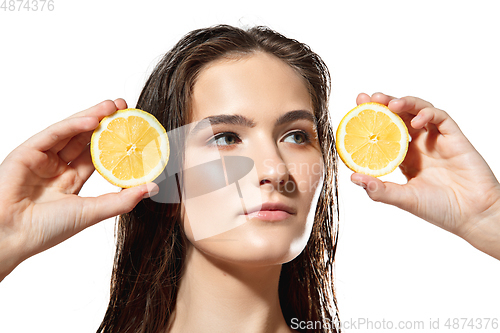 Image of Citrus. Close up of beautiful female face with lemon slices over white background. Cosmetics and makeup, natural and eco treatment, skin care.