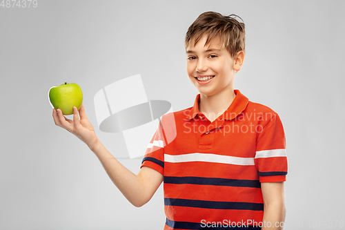 Image of portrait of happy smiling boy holding green apple