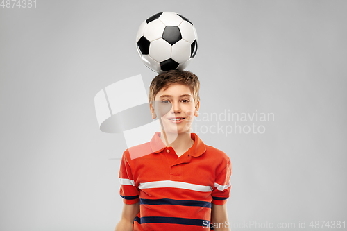 Image of happy smiling boy with soccer ball on his head