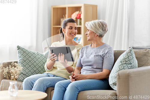 Image of daughter and senior mother with tablet pc at home