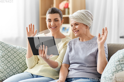 Image of daughter and mother having video call on tablet pc