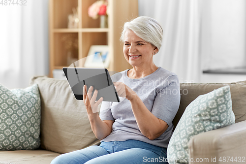 Image of happy senior woman with tablet pc at home