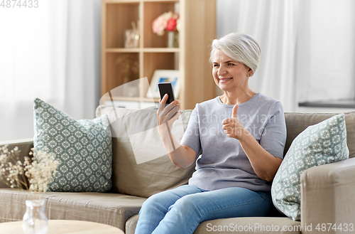 Image of senior woman having video call on smartphone