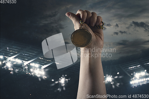 Image of Award of victory, male hands tightening the medal of winners against cloudy dark sky