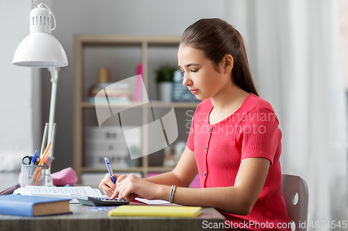 Image of student girl counting on calculator at home