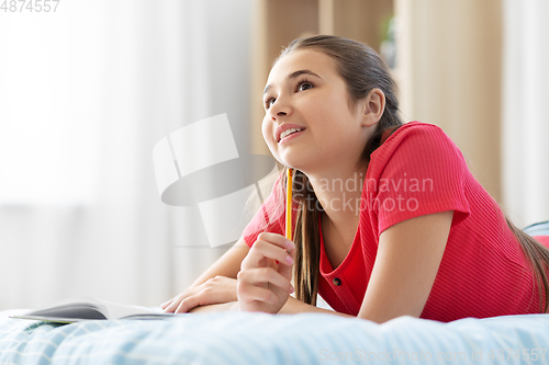 Image of teenage girl writing to diary at home