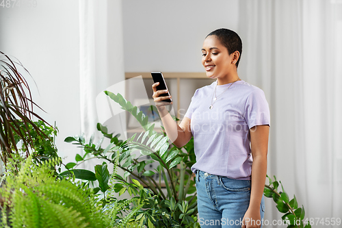 Image of african american woman with smartphone at home