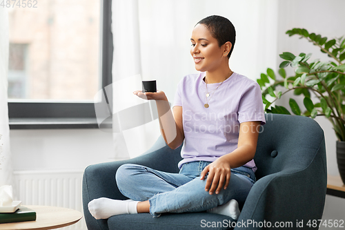 Image of african american woman with smart speaker at home